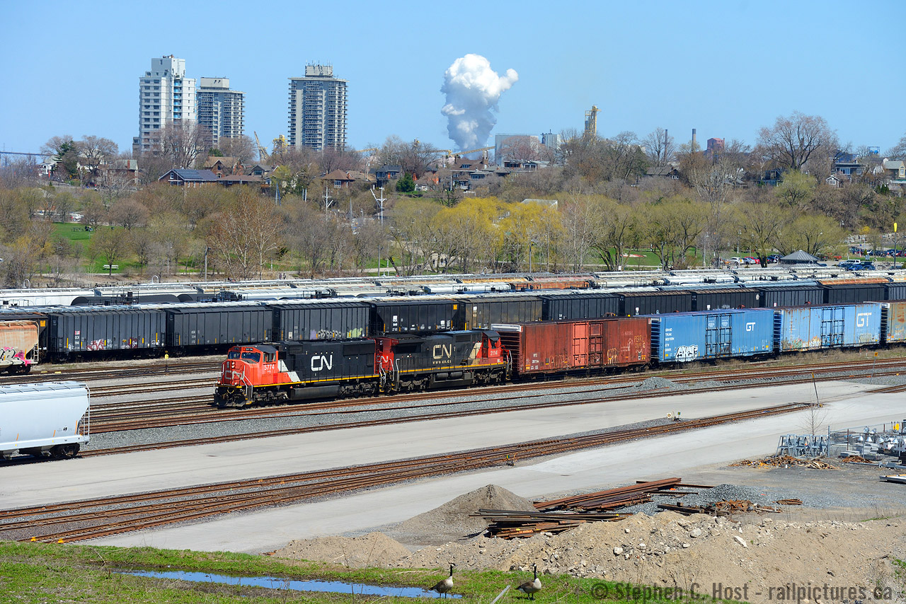 I'm not convinced i'm standing in the same spot as Doug's shot of similar location in 1964, but i'm close. Here's the 2019 view from near the end of Crooks St - Crooks St is almost unshootable now as the trees have grown ever taller, but you can walk down an embankment recently cut down of trees (by the landowner, as it blocked their view!). A couple Canada Geese stare me down as 422 passes eastbound on the Oakville sub. The harbour as seen in Doug's shot was filled in, not sure initially what for but now for the park. The hillside must have been wide open in the 60's.