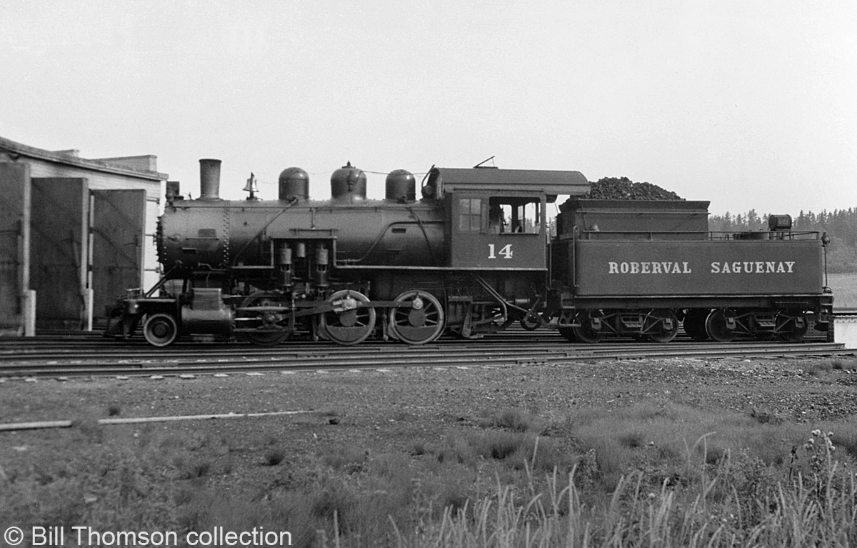 Roberval & Saguenay 2-6-0 #14 (a 2-6-0 "Mogul" Built for the R&S by MLW in 1926, later sold to the Alma & Jonquieres in 1941) is pictured by the railway's roundhouse in Arvida QC, circa 1940.

Bill Thomson collection photo (photographer unknown).
