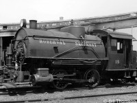 Roberval & Saguenay 15, a small 0-4-0T Tank engine, is shown parked outside the roundhouse in Arvida QC, Circa 1940.<br><br>R&S 15 was originally built by MLW in 1923 as Quebec Development Co. 104 and changed hands a few times: to Alma & Jonquiere 1, sold to R&S 15 in 1928, to Alcan 15 in 1951, and has been preserved on display at a pulp mill museum in Chicoutimi as R&S 15.<br><br>Bill Thomson collection photo (photographer unknown).