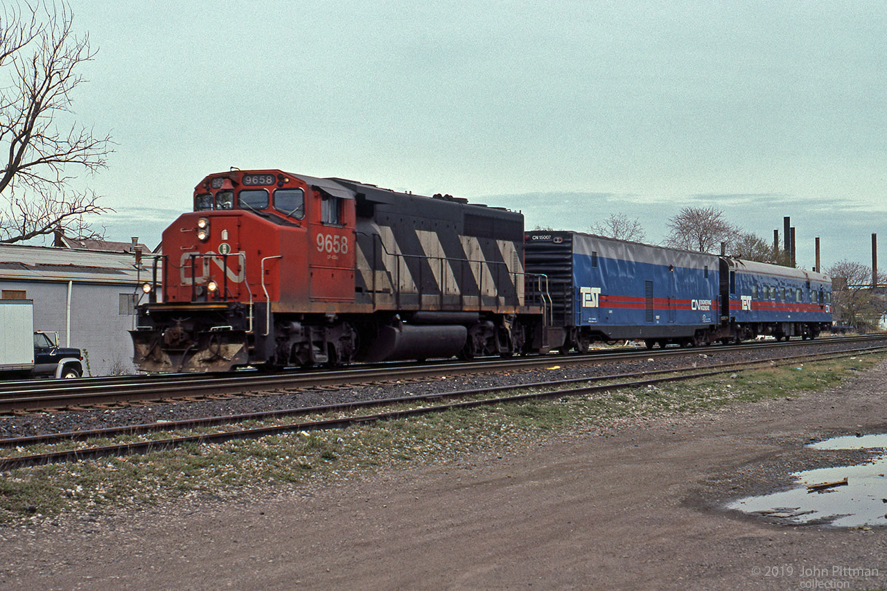 CN 9658, a GMDD GP40-2W built in 1976, leads a CN Engineering TEST train through Hamilton. First car is CN 15007.
Slide mount indicated Gage Avenue Hamilton as location. Current views near that crossing do not show the same landmarks, things change.