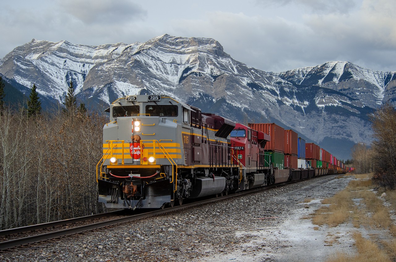 Wearing heritage colours, CP SD70ACU 7015 leads train 100-24 out of The Rockies east of Exshaw, AB.