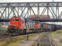Peter Jobe photographed CN 2018 heading westbound in Toronto near Cabin D. There is an over-and-under with a TTC PCC on the bridge over the tracks. There are even tell tails still hanging down in the top left.