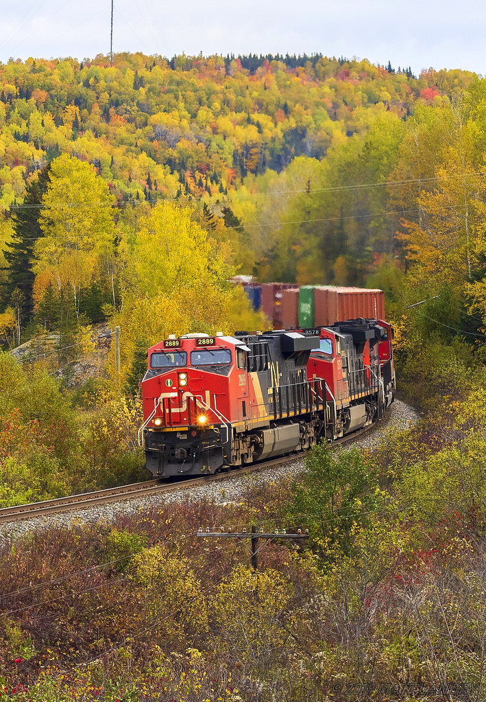 An AC is in charge of stack train 121, as they round the S-Curve at Lac Baker, New Brunswick in some Fall colors.