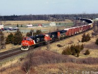 CN ES44DC 2233 leads two other units on eastbound train 360 at Mile 187 of CN's Kingston Sub, passing over the County Road 6 crossing in Amherstview, Ontario (just west of Kingston). Note the new replacement plow applied to the front of 2233.