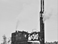 CN steam pile driver 50825 is shown in action pounding away at the west end of the bridge at Field, Ontario.  Notice that there is a five man crew: two on the pile driver itself, two on top of the bridge, and one almost under the bridge making sure the support is placed where it is needed.  KaThump KaThump KaThump  great sounds and all the smells were just a bonus!