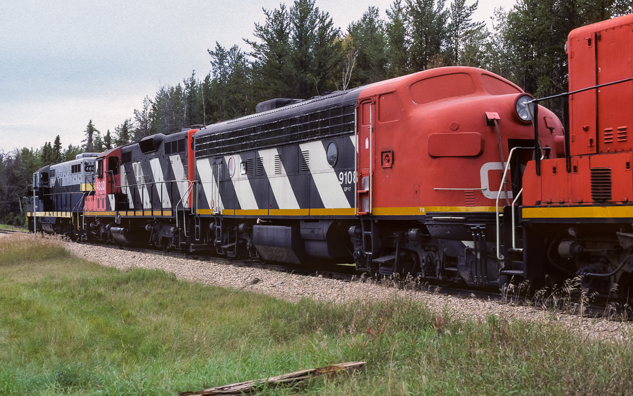 This is the 9150 after being converted to a B unit. Again, from the CNRHA, it was released back to road service in December, 1984. Here it is working with the 4603, 4330, 9108 and 4216, hauling loaded sulphur hoppers to Edmonton. The actual day is iffy, but the first few days of September for sure. This photo was shot a few miles west of Redwater. From the date this picture was taken, the 9108 only has a couple of years of life left. The CNRHA reports it was retired in December, 1989. If these units had been easier to get in and out of, I would think they may have had longer lives, like their GP9 brothers. Please see my neighbouring photo for the first part of this caption. Thanks.
