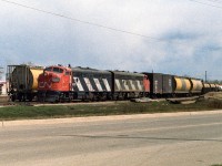 To complete the first and last of the rebuilt F7a's, here is the 9179 in the spring of 1983. The 9179 was previously the 9120 before rebuilding in December/74. It will go for B unit conversion in the fall of 1984. The crew has just finished picking up a couple of loaded cars from the elevators and returning back to the train. Of interest is the lack of yellow reflective strip below the zebra stripes. Also, and less noticeable, are some of the changes made on the front for snowplow service. The most obvious of these being the semi transparent number boards, only going to see those numbers at night. Another nice bonus is the 2 white flags flapping. Typically at this time, it was 2 sticks with some white left around the shaft. The rest of the flag either torn or flapped off. Please see my neighbouring photo for the rest of the caption. Thanks. 