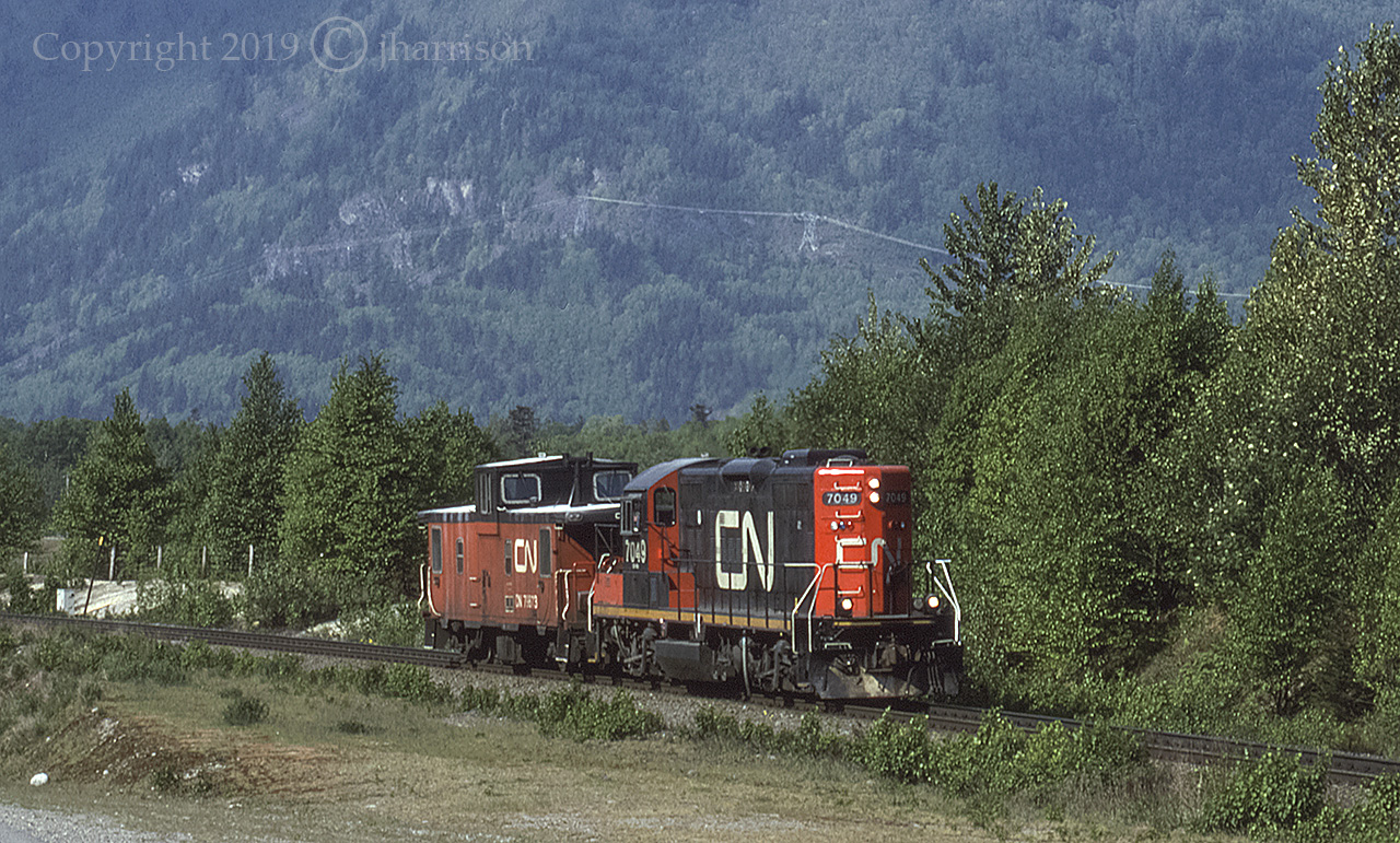 CN 7049, an EMD GP9RM built in 1957, is headed east and approaching Hope with Caboose 79873 at Cheam View, on CN's Yale Sub. Not sure of exactly when but, Caboose 79873 was put out to pasture at the Woodlands and Meadows Perennial Nursery & Gardens in Princeport, Nova Scotia. GPS is approximate.