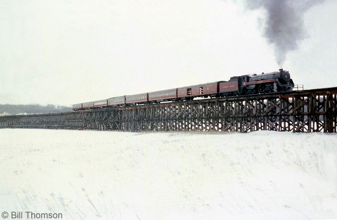 Here's another view of Canadian Pacific Royal Hudson 2857 with its short fantrip excursion train, on the giant 2142' long wooden Hog Bay trestle, during a photo runby stop just outside of Port McNicoll on CP's Port McNicoll Subdivision. Note the open doors on the baggage car with wood blocking, allowing riders a chance to lean out and witness the sights, sounds and smells of riding behind a live steam engine up close.

Planned photo stops and runbys such as this were common during excursions, as they allowed passengers and attendees a chance to hop off to photograph the train they were riding at different points along the line, and then re-board and resume the excursion again. Often times, they were planned for notable points along the line, including landmarks such as bridges, stations, junction points and the end terminus of the line (such as the visit to Port McNicoll during the trip to visit some of CP's last steam engines in regular freight service).

A wider view of the bridge and train can be found here: http://www.railpictures.ca/?attachment_id=24230