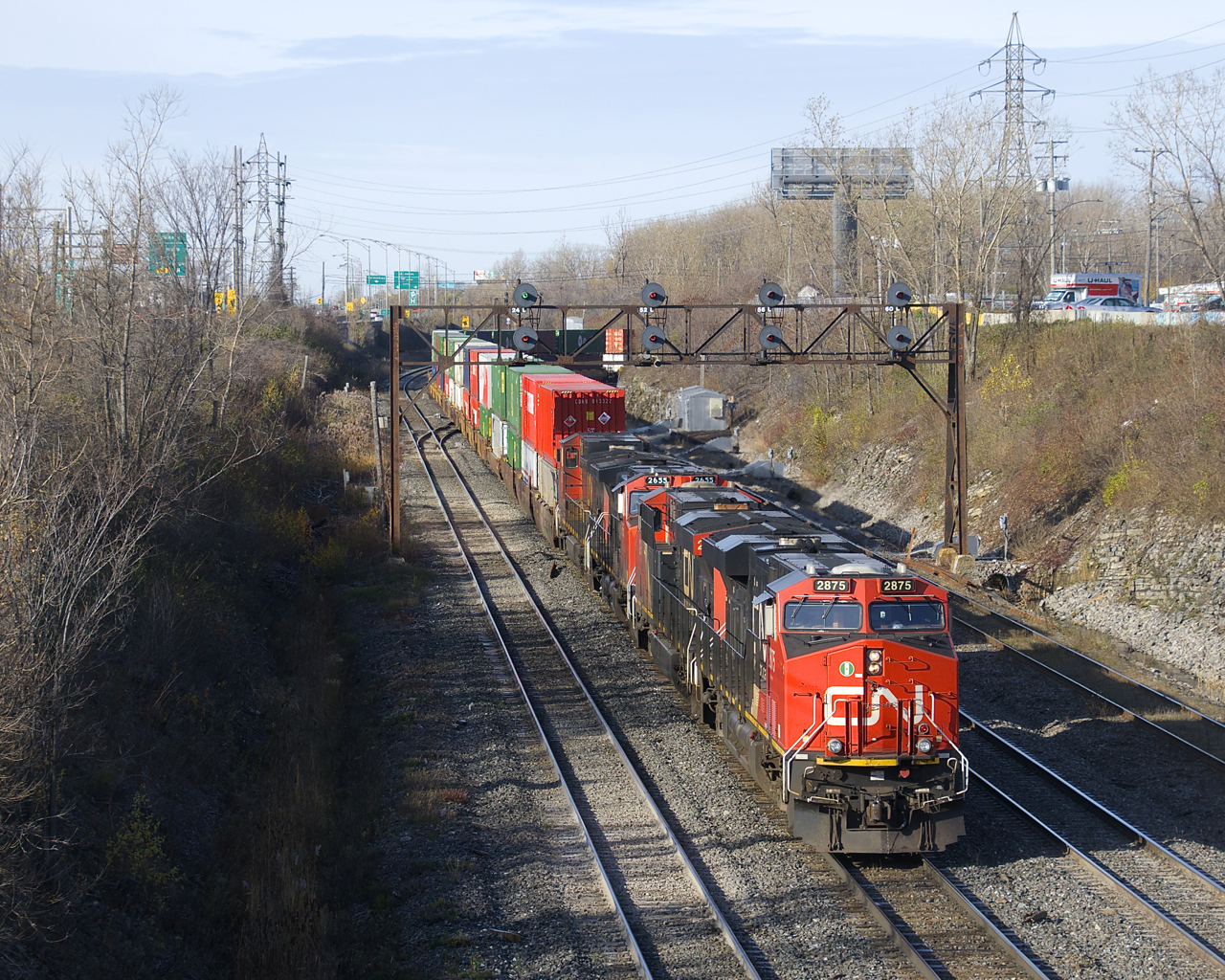 A shorter than usual CN 120 (456 axles vs an average of 620-630 axles) is exiting Taschereau Yard with CN 2875, CN 2964, CN 2655 & CN 2622 for power (and no DPU, uncommon), the last of which is isolated in deference to its shorter length.