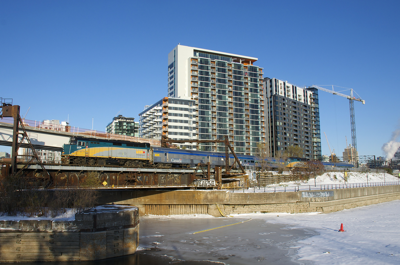 The combined VIA 601/603 passes the now obscured Wellington Tower with VIA 6438 up front and VIA 6405 mid-train.