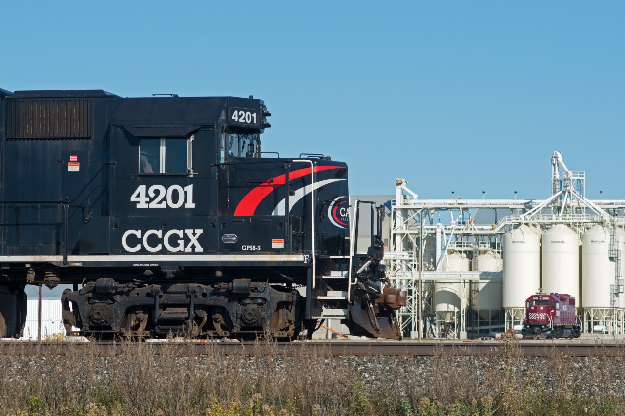 Cando waits next to the main line for CP to arrive with their cars while grain terminal switcher HLCX 3839 takes the weekend off.