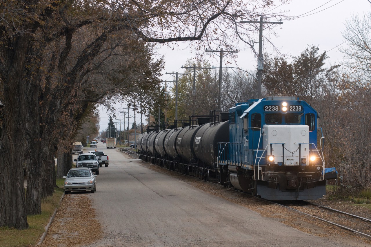 A dreary October evening finds Southern Rails Cooperative dragging a cut of cars from the CP interchange along Home Street in Moose Jaw Saskatchewan. A crew member driving ahead in a pickup and flagging crossings meant there was little to no whistle/horn noise as these guys rolled through town.