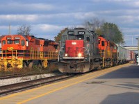 Goderich-Exeter Railway (GEXR) road train 431 with GEXR SD45T-2 3054, RLHH SD40-2 3403 and GEXR SD40-2 3394 are accelerating westbound by the Kitchener VIA Rail station. To the left, QGRY 2008 and SLR 3806 await their next assignment on 584 after having just returned from Guelph on train 580.  