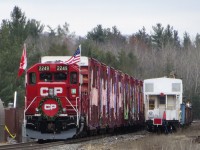 The holiday train rests during the mid day show at Midhurst. On the right tie removal equipment is parked on the spur that was once the siding. 