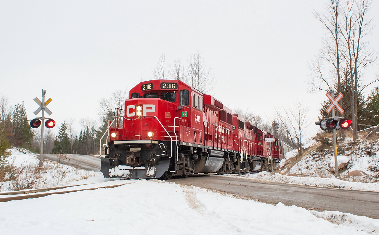 I was up in Peterborough for a couple of days for meetings, so figured since I was in the area I'd check out things on the Nephton/Havelock Subs before heading back to Hamilton. I lived in Peterborough from 2008-2012 and worked across the street from the Havelock Sub for a couple of years of that. Any time I heard a train coming by, I'd head over to the window and watch. On weekends I'd often get out of the city and go exploring, and one of my favourite places to go was the Nephton area, though with the schedule of the trains here I never did see a train on the Nephton Sub back then. I also lived on Lake Street for a while, and recall the tracks going across there before they were ripped out. I did hear a train coming through once in that time - I believe there was a customer somewhere that received plastic pellets. This was long before my days of shooting trains, though, and since I started actively railfanning a couple of years ago this had been one I had been intending to get to for sentimental reasons. I finally made that happen, catching T06 on the return trip from the mines after my Friday morning meeting had wrapped up. Pictured here, 2316 leads T06 southbound on the Nephton Sub towards Havelock.