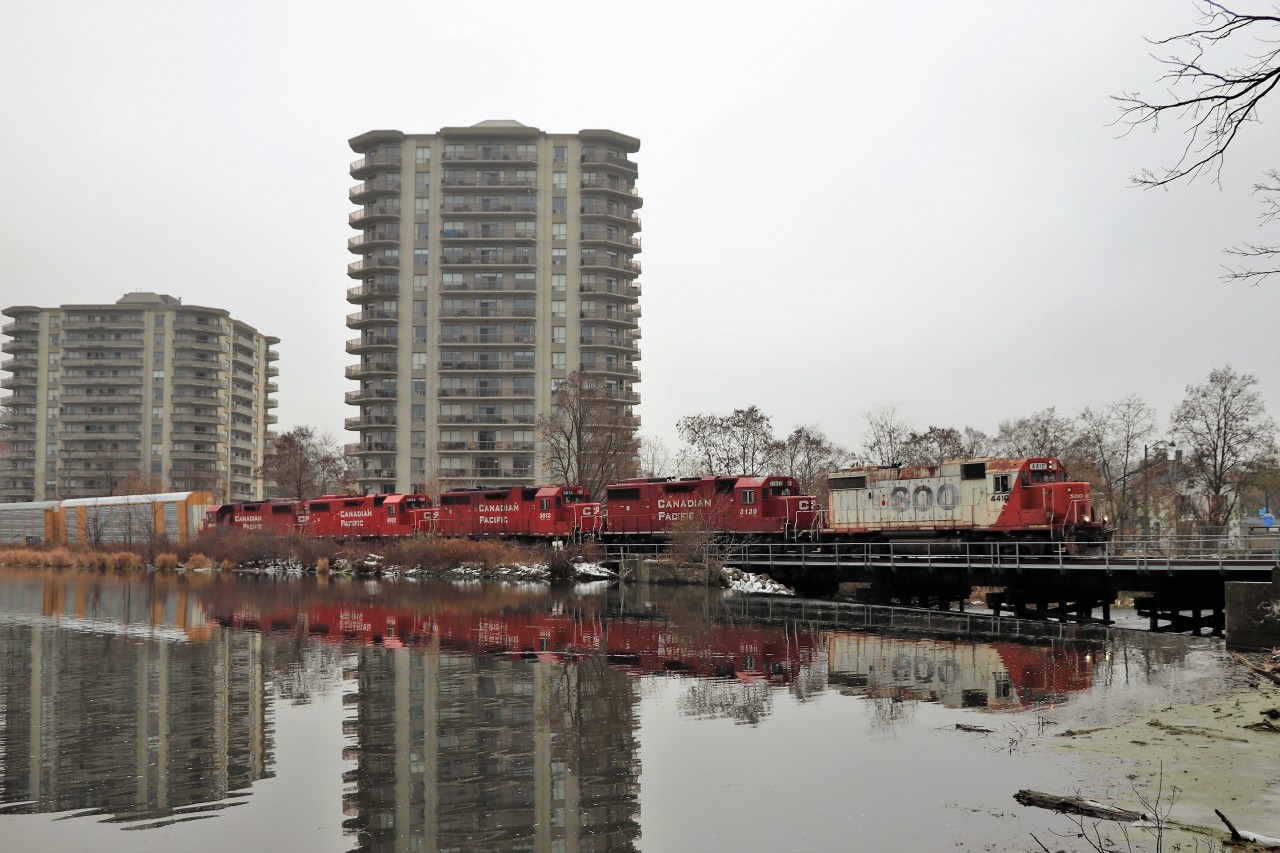 I once again got lucky here. I was out to shoot CP 651 when it got cleared with an "after". Well I hear SOO 4410 so off I went to  the old Cambridge train station just in case it was going to work locally. It headed down the spur so I took off to this location in the park. The light fog and lack of any sun made this shot available.
SOO 4410 with four of its GP38 friends glides over the Speed River on the approach to the Toyota plant.