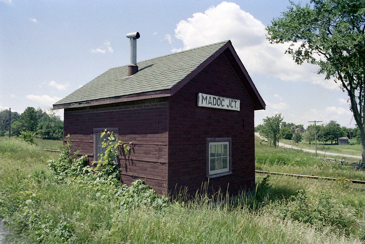 This image somehow has "old time" written all over it. And since it has been a long time since I shot this photo, I'm hoping someone on this list can explain its' significance. The namesign appears to be part of the set-up, and not a sign lifted from a post along the RoW. If there was a junction here it might have been the line into Madoc and a split over to Bonarlaw. The railroads many years ago had a considerable number of these quaint little shanties along the way. Many were tool buildings, storage sheds, but this one appears to have been a register office at one time. Anyone know?
