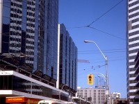 The 1980's were a transition era for the TTC's streetcar fleet: the introduction of new CLRV streetcars in the late 70's/early 80's displaced a lot of the aging PCC fleet, notably the remaining secondhand cars the TTC bought. Most of the A6-A8 class PCC's built new for the TTC (4300's, 4400's and 4500's) continued to soldier on side-by-side with the CLRV fleet, but the later arrival of the articulated ALRV's in the mid-late 80's culled most of the fleet. A group of the A8's were rebuilt as 4600-series A15's, and used for a few more years of service on the new Harbourfront LRT line into the 90's.
<br><br>
Here, TTC PCC 4473 (an A7-class car built in 1949) and CLRV 4059 (a new CLRV built in 1980) wait on Dundas Street for the light at Bay Street, next to a Ford L-series "Louisville" truck operated by Tippet-Richardson, a popular moving company around the city at the time. The new Atrium on Bay (built early 80's) towers on the left, and the Eaton Centre's north tower (that contained Eaton's head offices) as well as their parking garage line the south side of Dundas. In the background is Yonge Street, and Ryerson's Victoria Building (seen <a href=http://www.railpictures.ca/?attachment_id=31453><b>here</b></a>).
<br><br>
<i>Original photographer unknown, Dan Dell'Unto collection slide.</i>