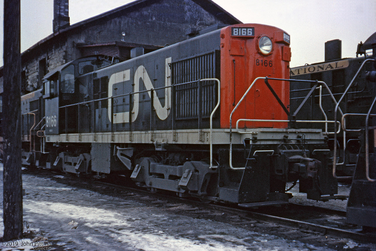 CN 8166 is an MLW S-4 switcher built in 1956. It got an early repaint to the CN noodle scheme.
In 1961 this scheme was the exception. A few years later, commonplace. With MLW switchers gone, of interest again.
Only the date was written on the slide mount, however the provider indicated that it was a Reg Button photo taken at the old engine house in Hamilton Stuart St Yard. The building matches well with one in Doug Page's image of the Hamilton roundhouse area taken in mid-1960.
