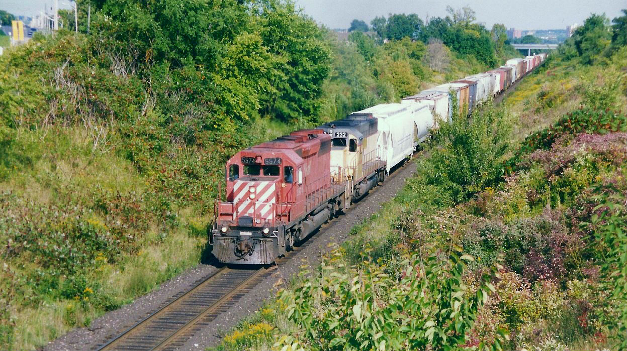 Canadian Pacific train 511 is climbing the grade on the Windsor Subdivision as it heads westbound out of London approaching the Sarnia Road overpass. Powering the train are SD40-2 5574 and I&M Rail Link (IMRL) SD40 232. This westbound was the third to depart Quebec Street on the Windsor Subdivision that afternoon, as it eventually would follow 509 and 503 to Windsor.