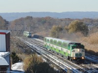 GO train 1960, the weekend morning 6 coach train departing Niagara Falls at 08:30 to Toronto, has passed 6 car counterpart GO 1961 waiting at CN Snake - the Niagara-bound train left Toronto Union at 09:00. <br><br>
Points of interest include the GMD F59PH that leads GO 1960 and the use of Track 1 by GO 1961 (almost exclusively for CN freight in recent years).<br><br>
With GO 1960 clear, GO 1961 will be getting its signal to continue, crossing over Track 2 for the single hot (CTC signalled) CN track beyond Hamilton Junction. That bottleneck will presumably be eased in the not-too-distant future when the new GO Transit tracks from Hamilton Junction to Hamilton West Harbour GO station are connected and fully operational.<br><br> 
The train down at the signals has MPI MP40 GO 603 pushing, with Bombardier cab-coach GO 379 in the lead.    