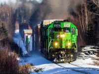 Maine Northern 6340, ex Southern Pacific, now in NBSR Green, leads westbound train 907 as they approach Cork, New Brunswick, negotiating the ups and downs of the McAdam Sub. 