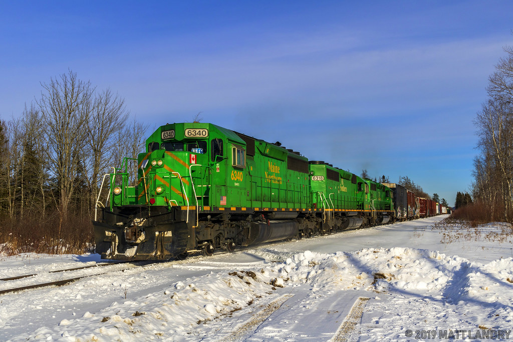 A trio of green power leads NBSR westbound train 907 at Prince William Station, New Brunswick.