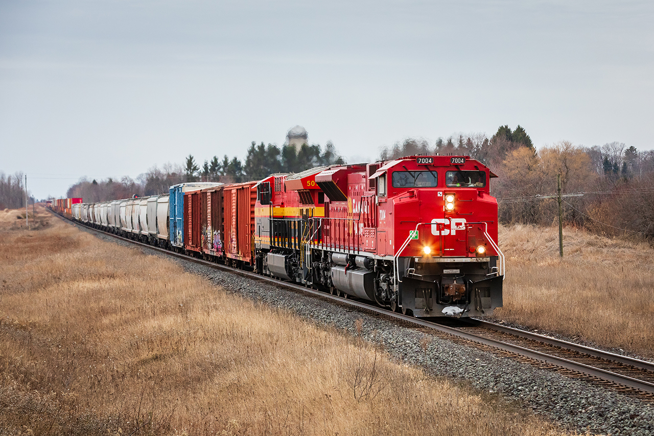 A photogenic pair of locomotives lumber a long and heavy no. 118 through the farm fields at Newtonville, Ontario.