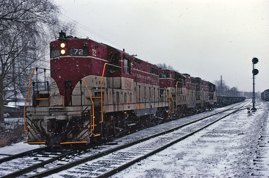 Another great shot by Ron Tuff. I would surmise that this is the returning train from earlier this day that ran to Welland and return. Most likely has just made a set out at the west end of Kinnear Yard.