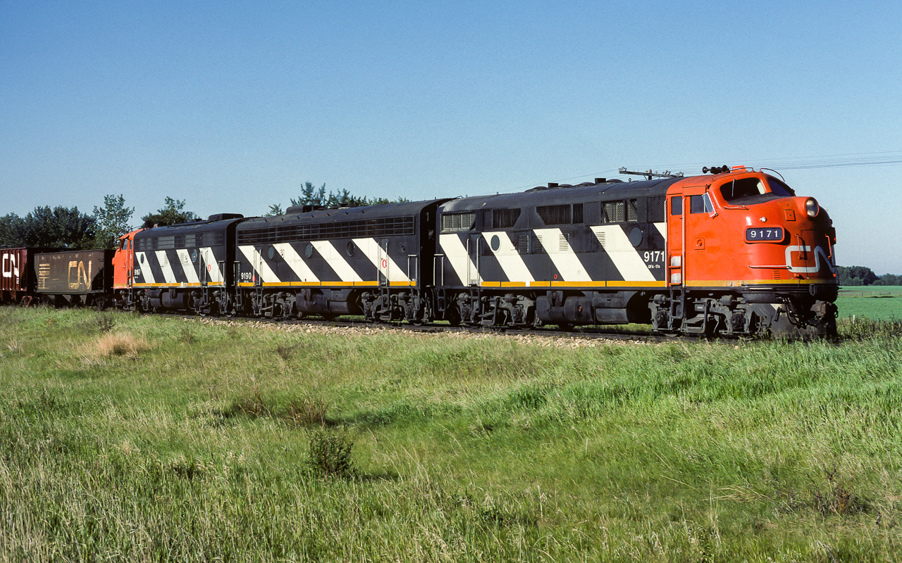Every few days, for 2 to 3 years, first thing in the morning, a train of empty sulphur hoppers would roll through Redwater. On this day, I could not believe my eyes when looking out the back window of the house after hearing the horn blowing. Its grab the camera, jump in the chase car and off to Egremont. Blue sky and sun, not too late in the morning either so there still is some light on the nose as the units head north. Leading up the 48 empty hoppers was the 9171, 9190 and 9167, with caboose 79286 bringing up the rear. This photo taken a couple of miles north of Egremont at 8:00. As was typical for these trains, they returned the next day around suppertime.