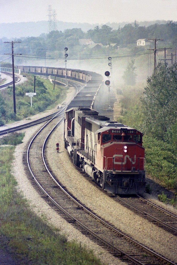 Not sure what is on this train. Looks like it could be ballast. Any rate, CN 9498 and 9447 are in a power braking struggle helping to hold back this heavy eastbound which has just come down the long (8 mile) Dundas Hill.
A scene from the past. I used to enjoy witnessing this action.