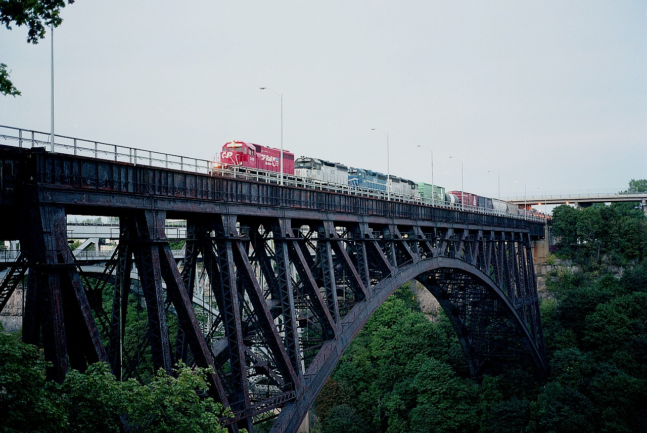 The most frustrating part about shooting trains in Niagara Falls was the fact most did not enter the city until sundown. I was getting very nervous waiting for this one as it slowly crawled over the former MCRR bridge spanning the Niagara River. The light had faded quickly and I hand held the camera at maybe 30th of a sec. Balanced it somehow, perhaps. As a result this was my only shot. By the time this train was wholly on the Canadian soil, it was too dark to shoot.
A real shame, too. In the height of the "leasing era" of the mid 1990s, this day's #521 had CP 749 (x-SOO) and three leasers: HLCX 662, 3060 and 663.
The 3060 was x-CR. Interesting thing about the 662 and 663 is that they are two of three former Amtrak locomotives leased. (The other was 664). Looking for temporary power caused a real frenzy back then as CP was, for a time, desperate..
