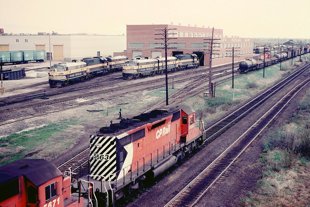 CP 5663 leads a Chalk-River Sub bound freight past a vast array of interesting Ontario Northland power sitting outside their main diesel facility at the south end of North Bay. Although it was only the May two-four weekend, it was incredibly hot and smoggy for the time of year. Heat off the rock and ballast made it tough going wandering the yard that afternoon. But some great photos. Besides power out front there was also an old CP MLW switcher (so it looks) working and CN power out back as well. Back then, we were free to roam. Those days are over.............