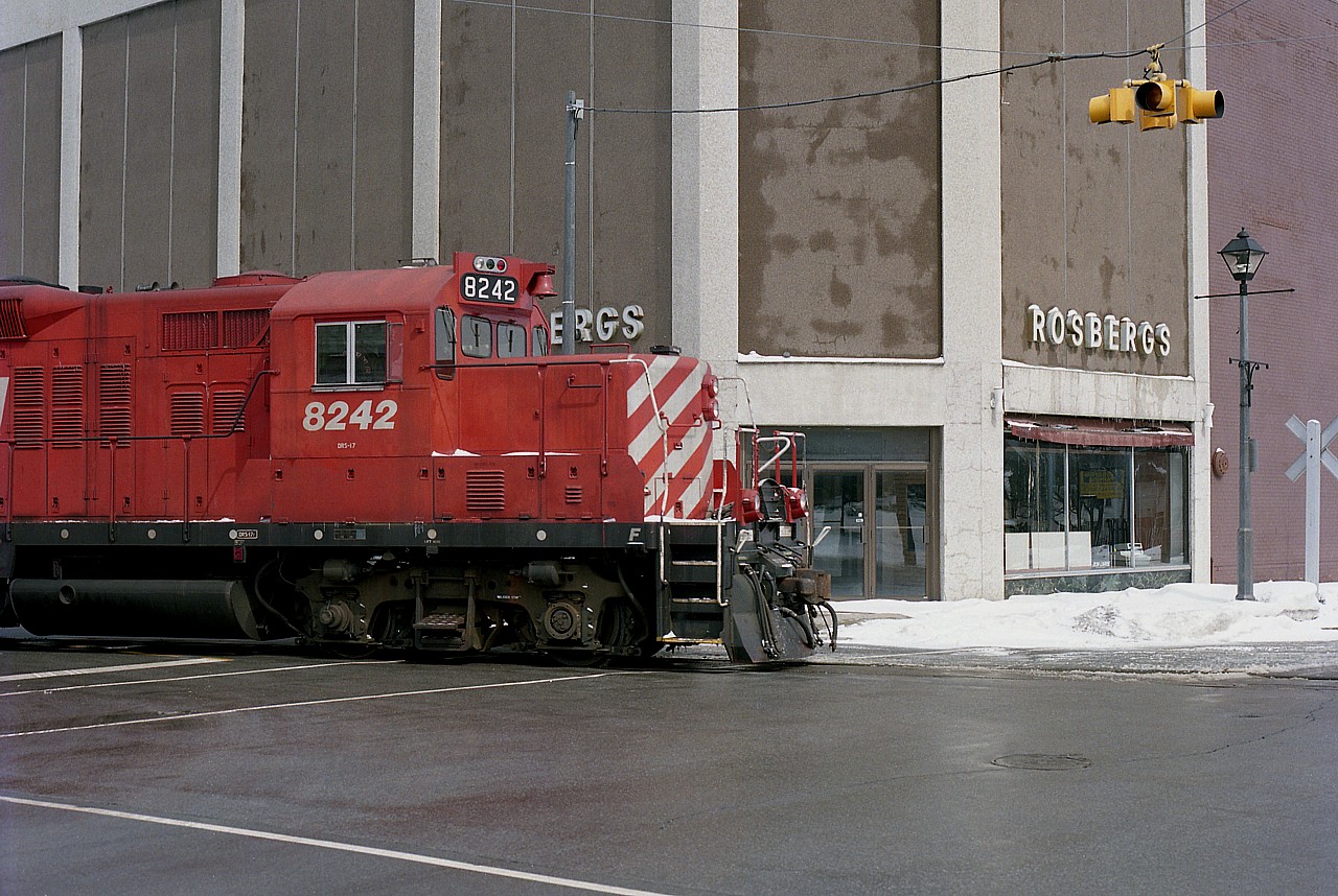 Almost surreal. :o) The boys on CP 8242 make sure they look both ways before crossing the street. Rosbergs Department Store has long gone out of business. It would have been interesting to see this local, on its way back from the CN yard to CP Montrose, thread the pedestrian and automobile traffic on a busy day. But, by 1993, there is little business remaining and running this line between the two major carriers is a breeze.
View is at the corner of Queen and Erie Sts in the Falls. The loco sure looks out of place.