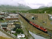 Coal empties from East Chicago to Line Creek, in B.C.'s Elk Valley, pass the old coal mining town of Coleman on the east slope of Rockies. The remains of the old mine tipple, yard and coking ovens lie to the right of the train