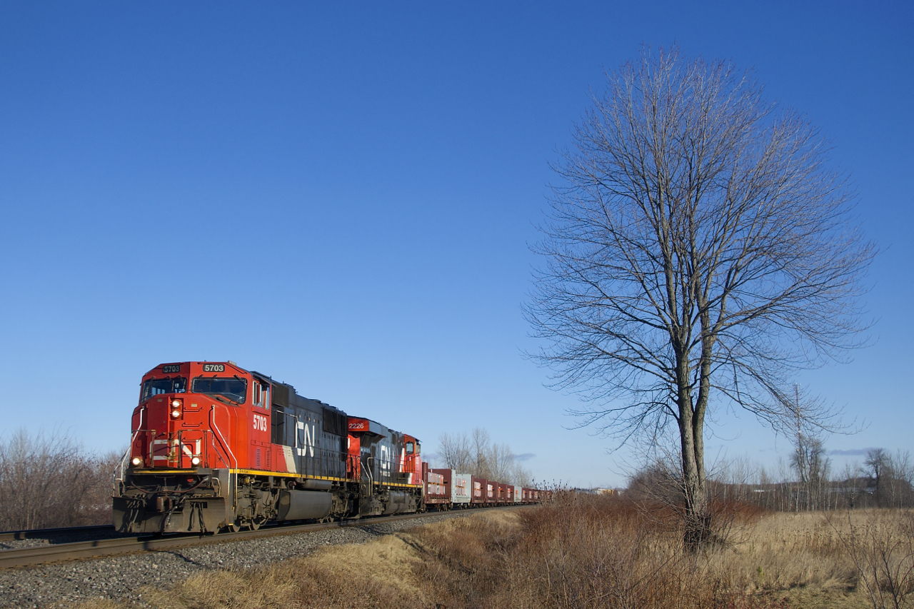 CN 369 has CN 5703, CN 2226 and 120 cars as it approaches the Chemin de la Rivière-Delisle crossing at MP 35.74 of CN's Kingston Sub. Up front are a string of aluminum cars from a number of Rio Tinto Alcan plants in Northern Quebec.
