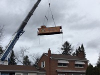 Its a bird? Its a plane? No its a flying caboose! 
My good friend and fellow engineer (VIA) Dave W shot this photo yesterday of his caboose being lifted over the home he just sold in Willowdale, Ont before it was loaded on a flatbed truck on its way to a good home at the Halton County Radial Railway (to be confirmed).
Dave had always wanted a wooden caboose but they were hard to find in decent condition condition. Luckily I was working as a brakeman in the mid 80's on a transfer job that CN operated from Mac Yard to Leaside via Oriole (CN Bala Sub) and the CPR to Leaside when I noticed an abandoned CN 78653 in Leaside.

After some inquiries Dave was able to purchase the van from CN and had it moved to a friends land between the CN and CP mainlines at Newtonville, Ont. CN 78653 sat in Newtonville for many years until Dave bought an home with an acre of land near Yonge St and 407. 
Dave extensively rebuilt CN78653, including new tongue n groove boards outside, insulation, 2 original oil burning stoves and many other original touches, but the best part...the original CN red paint and CN "serves all Canada"  maple leaf logo purchased from CN. The van was used a a pool house for all the years Dave and his family lived in Willowdale. 

With retirement from VIA pending Dave put the house up for sale and did not have any plans to take the caboose to his new property in Ballantrae, Ontario but wanted to give CN78653 a good home with fellow rail enthusiasts.

Hopefully many generations of railfans will be able to enjoy  this icon of Canadian railroading for years to come.
 Thanks for preserving and this classic CN caboose Dave.