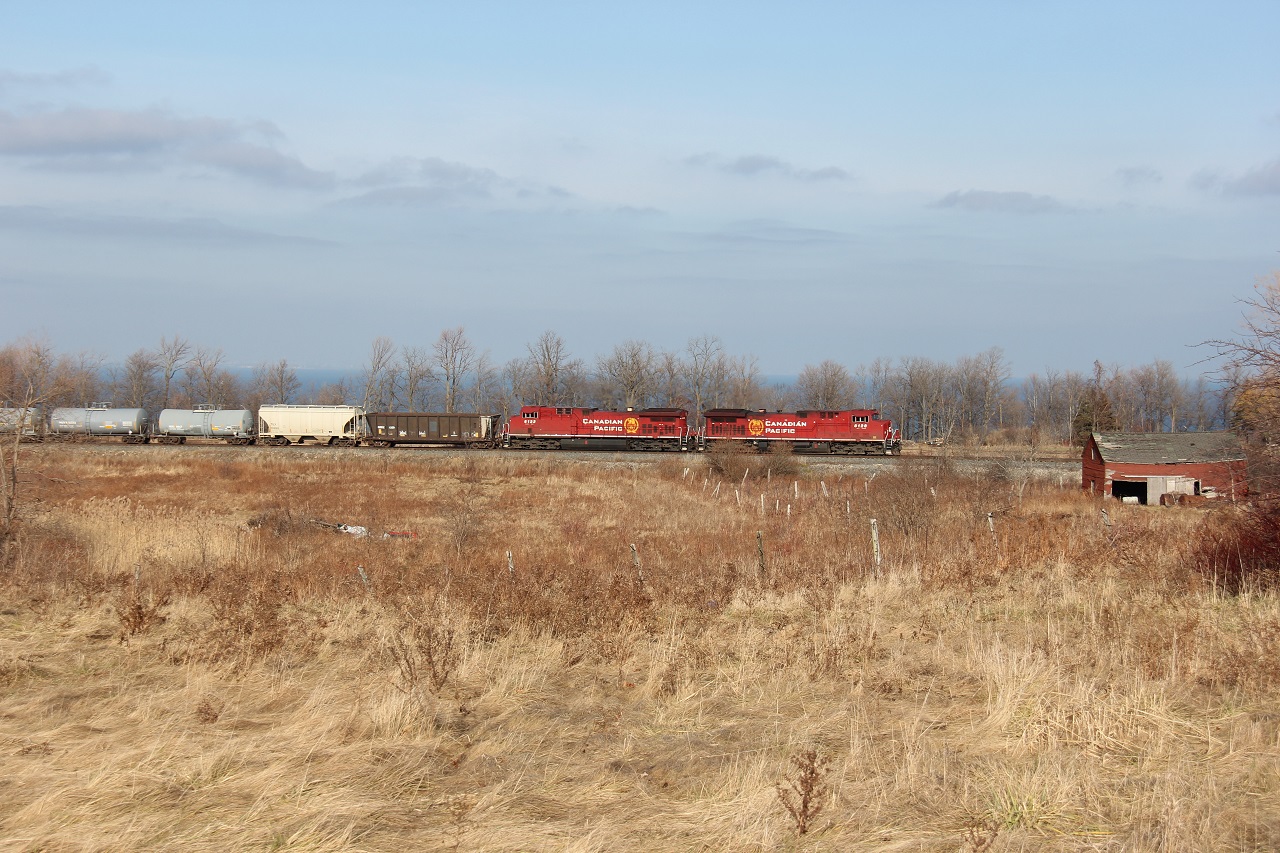 CP 246 heads eastbound towards Welland on the Hamilton Sub with a short train. The train is about to duck under Ridge Rd., just east of Hamilton city and at the edge of the escarpment. Lake Ontario can be visible in the background. I was going to shoot from the bridge but realized the lighting from there was sub-ideal so I made a last minute call to shoot from this vantage point. Time was around 13:55.