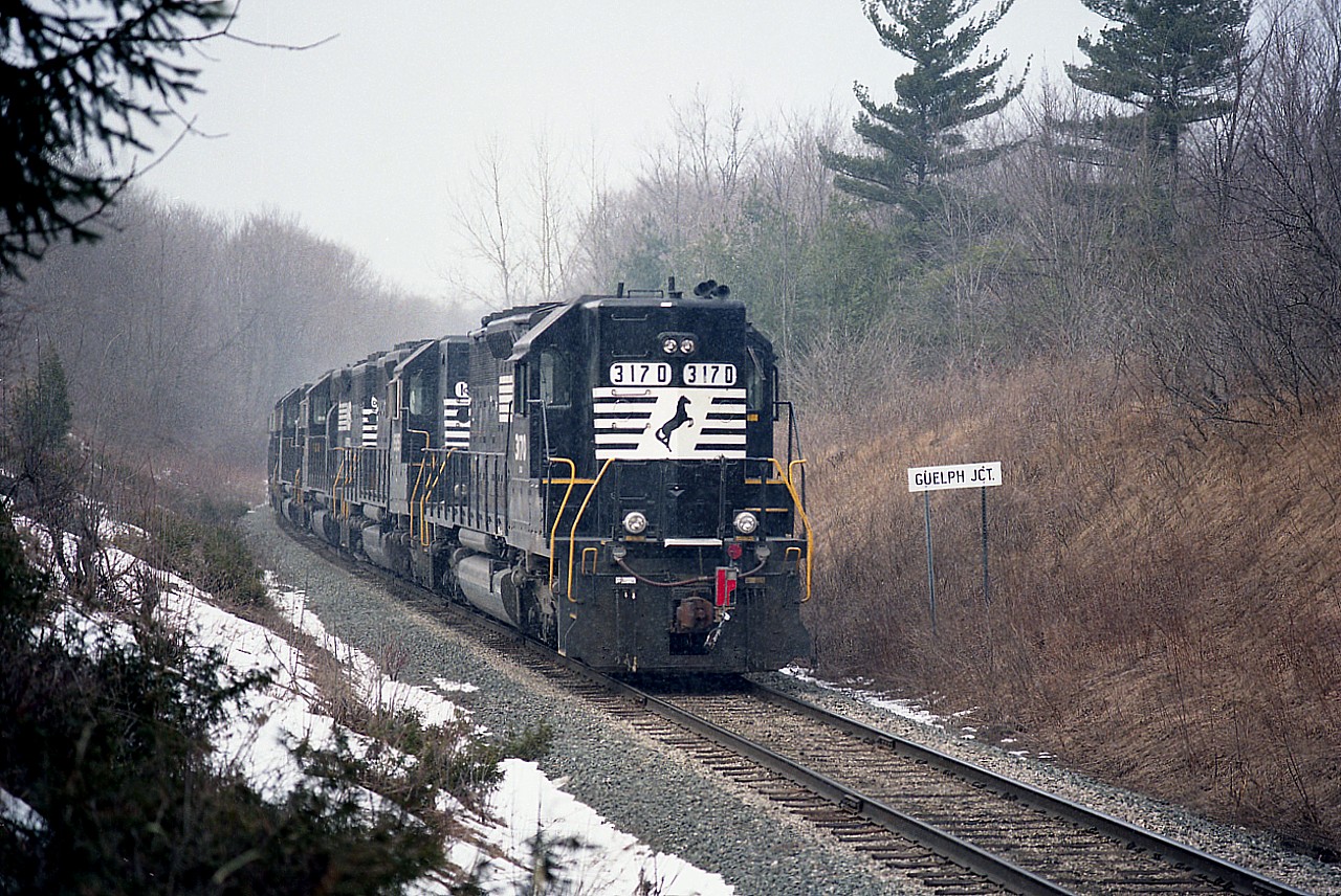 Something a little different. In 1997 CP was getting desperate once again for additional power, and as a result acquired this string of NS units. They moved as train #521, from USA to Toronto. Power from the rear unit (shown, note flag) NS 3170, 1585, 1606, 1607, 3173, 3194, 3176, 3193 behind leader CP 6045. In this view the consist is approaching Campbellville Rd crossing and then will run east on the Galt Sub.