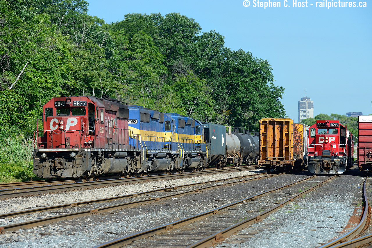 Here's a hot hazy summer day photo to warm us up. I posted a shot of this train  some years ago (back in my wide angle - not sure how to use it - days) but I've pulled out this more standard angle out that I much prefer - a classic TH&B view with some of the Hamilton skyline in view - and now, most  if not all of this motive power is no longer on the roster. Boy how good we had it then.. little did I realize most of this would dissapear in a couple short years. I didn't chase this.. I should have - we would chase the piss out of this now.