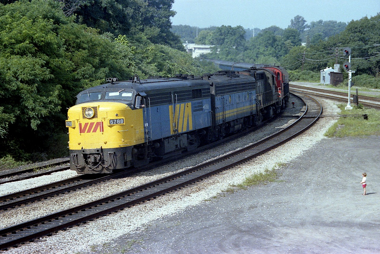 Another one of those what I consider now to be glorious VIAs of the past. Sure, they were great to see way back then, but we used to mostly take them for granted and focus on the freights. This is a Wednesday afternoon image, looking like a weekender......VIA 6788, 6627, CN 3116 and 3126 on the head end. I should have done a car count.
Solitary little rug-rat visible in this image. Makes me wonder if this curious soul is not one of those that is found trackside 40 years later and follows railpictures.ca? You just never know.