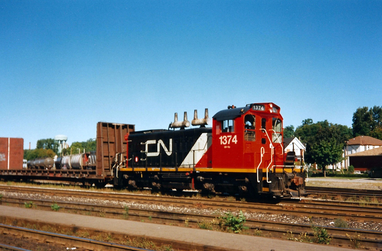 CN SW1200RS 1374 in it's newly applied CNNA colors switches Brantford yard on a quiet Sunday morning in 1993. I remember this well, as it was my first visit to Brantford to observe trains. My notes don't indicate it, however I remember 1374 later departing the yard and with cars followed by many many train horns, as it probably headed to Burford on what remained of the Burford Spur. I hadn't yet realized that line existed yet unfortunately as my dad and I were slowly just getting familiar with railfanning and the mainline was where our attention was. 

From my notes that day; CN 4129, 9565 and 9566 were also assigned to Brantford in the yard as well as cabooses 79770 and 79713. CN train 419 later came through with 5290/ 5109 and Windsor-bound 381 had 3510, EMD Leasing 772, which was ex-Conrail and 2101.