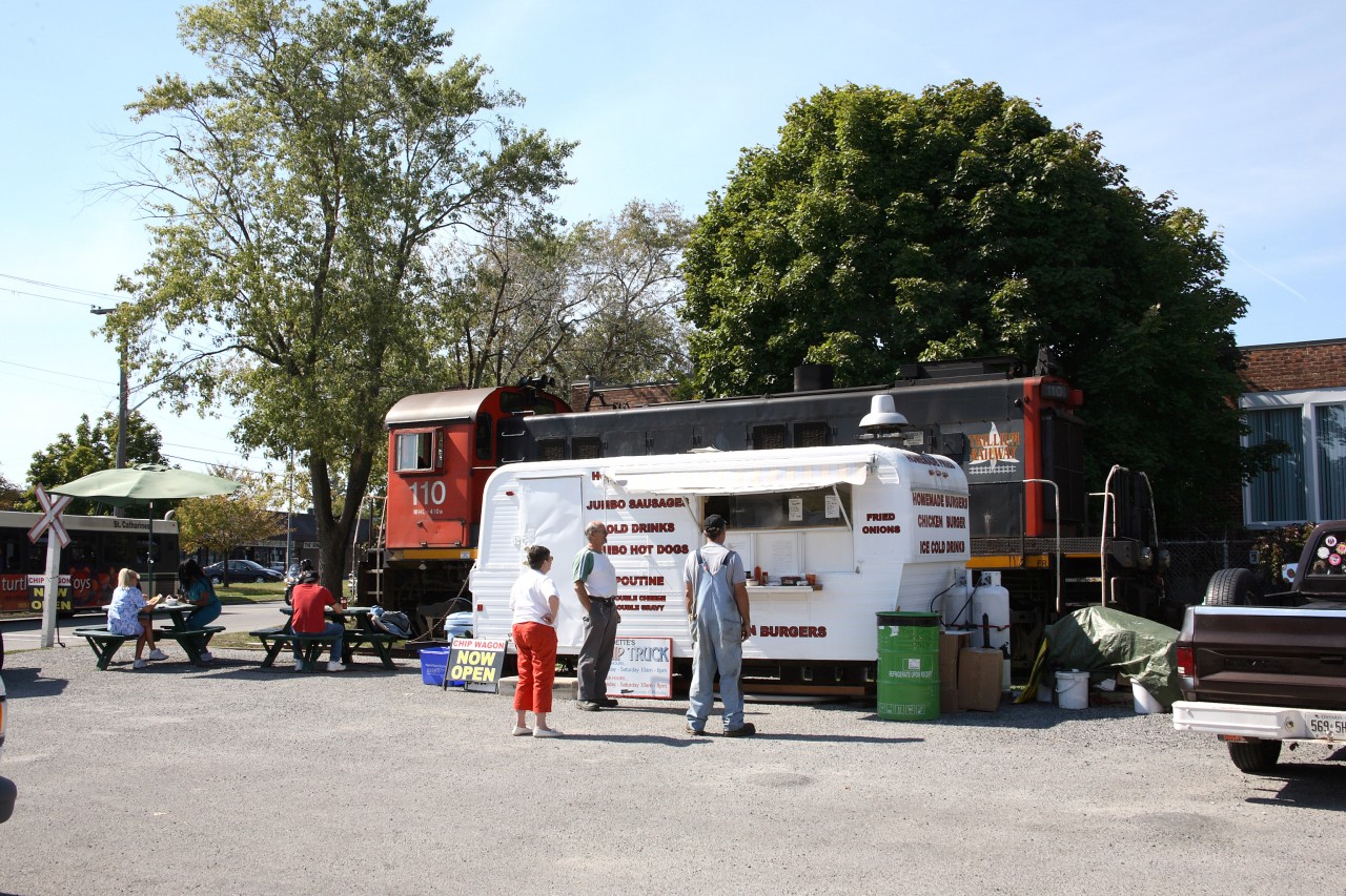 The walk is short and the timing was perfect !!  PCHR 110 on Trillium's Canal Job has just finished spotting a tankcar at a local customer.  The great smells of the local chip truck and the fact it is lunch time, makes for an easy decision.  While my conductor joins the line-up for some health food, I just had to shoot the scene. Yes, lunch was delicious at this railroad drive through !!
