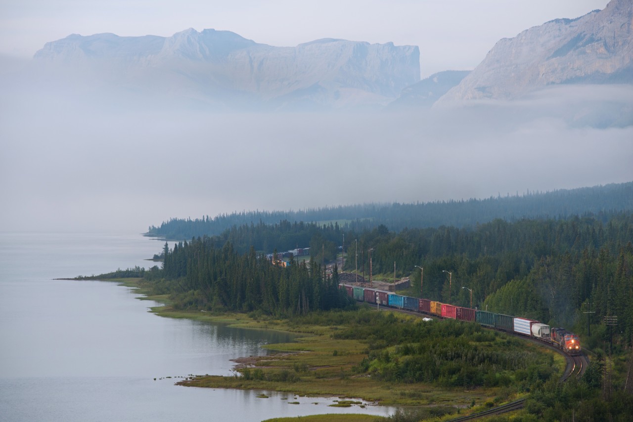 CN 412 departs Swan Landing as the morning fog creates an almost seamless blend between the Athabasca River and the Rocky Mountains