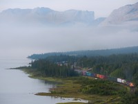 CN 412 departs Swan Landing as the morning fog creates an almost seamless blend between the Athabasca River and the Rocky Mountains 