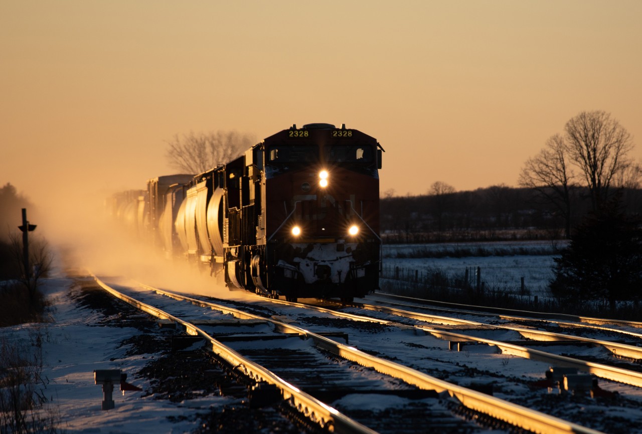 A few hours of tolerating the very cold and windy day had been well worth it, with constant VIA traffic and a few CN freights.  The sun was getting very low and with the clear sky, that magic golden colour began to take over.  My first thought was " I really need an eastbound " and I'll wait until the sun totally sets.
The railfan gods must have heard me, 'cause at the perfect time, CN 2328 East showed up.  The golden glint, and the blowing snow during its passage made the frozen fingers all worthwhile.