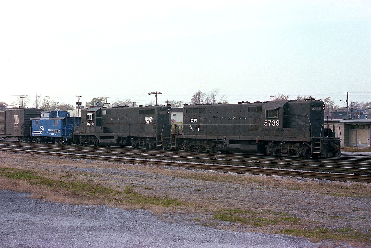 Conrail had been in existence a couple of years by the time I shot this, but the painting over to the "Big Blue" would be an ongoing project for many years. A couple of CR geeps, 5739 & 5795,  in their dreadful old Penn Central colours are seen here in front of the passenger station used only by the CP/TH&B budds by this time.
The 'Conrail blue' van is #19387 and the boxcar, Pacific Great Eastern, adds some history to the scene. These two locomotives were frequently seen in Fort Erie interchanging traffic.
