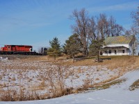After dropping rail on the south track between Obico and Cooksville, CP 5922 West provides the horsepower for this ribbon rail train passing many rural country side homes like this one on their way to Wolverton.