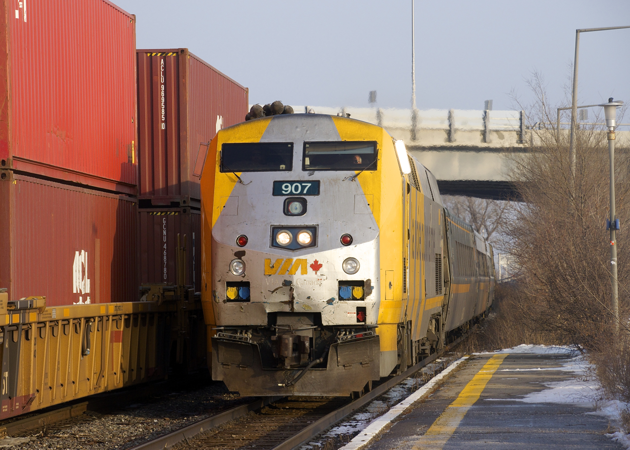 A late CN 120 is heading towards Taschereau Yard at left as VIA 635 arrives at Dorval Station with VIA 907 leading.